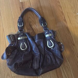 Purple leather bag with leopard interior.